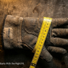 Industrial worker measuring hand circumference with a flexible tape measure to find the correct work glove size for safety and protection